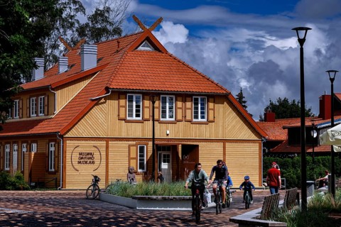 Traditional wooden house on the Curonian Spit with playing children and family, Nida, Curonian