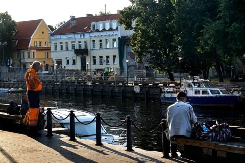 Anglers on the Dange in Klaipeda with a view of historic buildings and boats, Klaipeda, null,