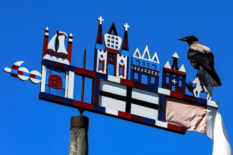 Colourful Kuren pennant with a bird on a bright sky, symbolism of the Curonian Spit, Nida, Curonian