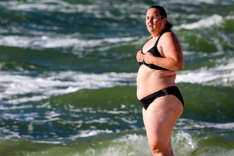Woman in water on Nida beach surrounded by waves of a summer sea, Nida, null, Lithuania
