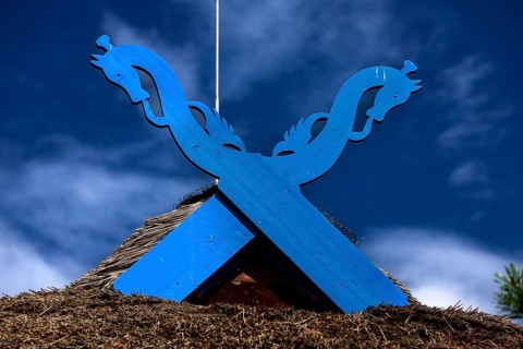 Blue wooden symbol on the pediment of the Thomas Mann House under a clear sky, Nida, Curonian Spit,