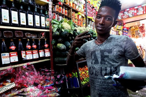 Man in colorful grocery store in Mekele, Ethiopia, between shelves of goods, Mekele, Ethiopia
