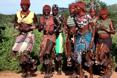 Hamer woman dance in traditional clothing during an initiation ritual. Vivid colors and traditional