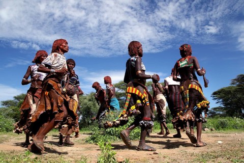 Energetic dance by Hamer woman in traditional surroundings as part of their initiation ceremony,