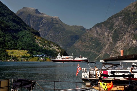 Hurtigruten ship in the fjord with surrounding mountains and water, Geirangerfjord, Norway