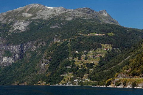 Green mountain slopes with road and fjord views, Geirangerfjord, Norway