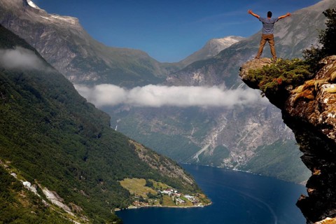Breathtaking view of the Geirangerfjord from Flydalsjuvet with one person on the edge,
