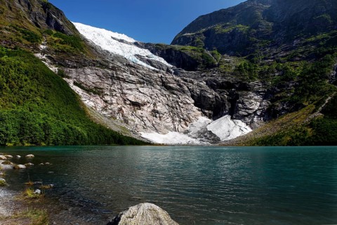 Bøyabreen Glacier Range stretches majestically against a blue sky, surrounded by steep mountains