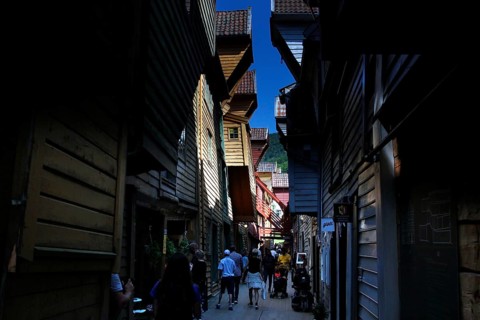 Shady wooden house alley in Tyskebryggen in sunny weather, Bergen, Hordaland, Norway