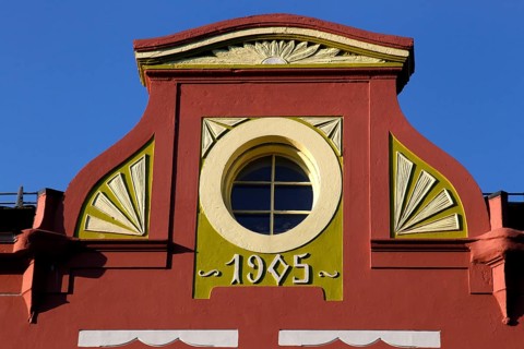 Detail of an Art Nouveau façade in Ålesund with round window opening and decorative ornaments,