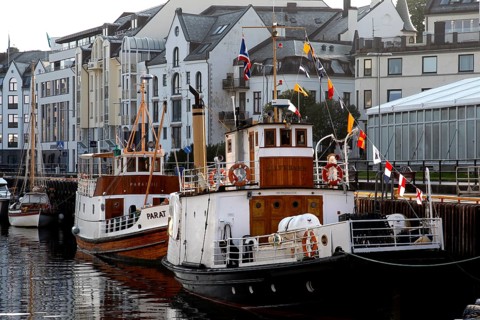 Boats in harbour in front of historic art nouveau buildings in Ålesund, Ålesund, Norway