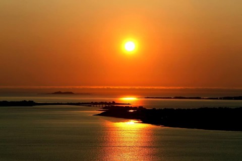 Peaceful sunset scene at Kniven viewpoint in Ålesund with orange sky, Ålesund, Norway