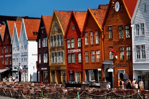Colourful historic buildings in the Hanseatic Quarter with people passing by, Bergen, Norway