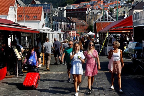 Lively scene at the fish market in Bergen with lots of people and stalls, Bergen, Norway