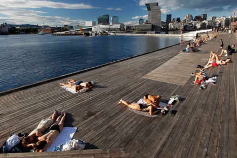 People sunbathe on a deck with a view of the Munch Museum in Oslo, Oslo, Bjøvika, Norway