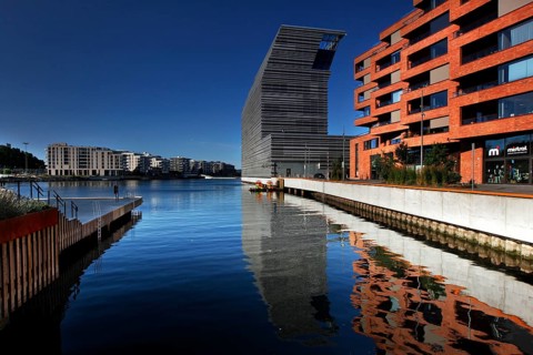 The Munch Museum is reflected in the clear water of Bjøvika in Oslo, Oslo, Bjøvika, Norway