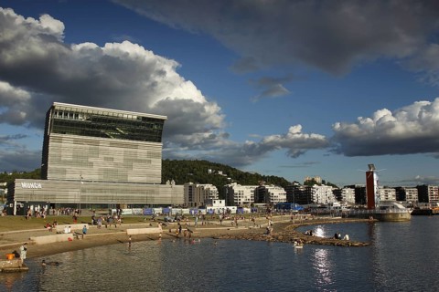 Modern building on the beach with dramatic clouds in the sky, Oslo, Norway