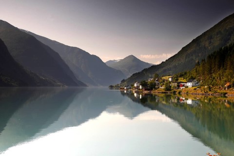 Reflection of mountains in the calm water of Fjærlandsfjord near Mundal, Mundal, Norway