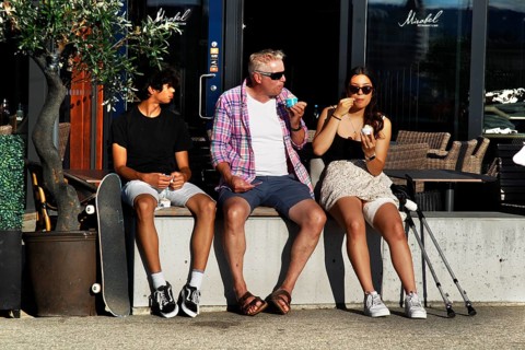 Passers-by sit and enjoy ice cream on summer day in Sørengkaia, Oslo, Oslo, Bispevika, Norway
