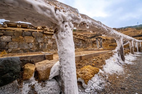 Salt covering the wooden structures and ground in the historic salt valley of anana, showcasing the