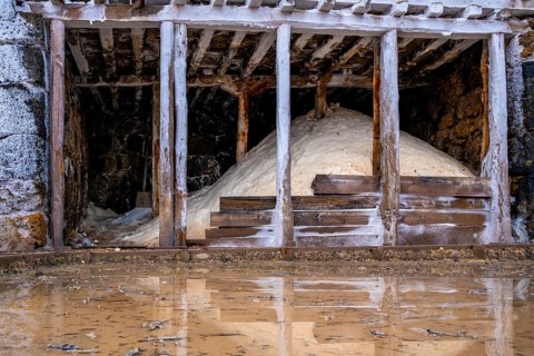 Salt piles stored inside traditional wooden structures at the anana salt valley, showcasing the