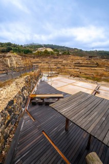 Terraced salt pans of the historic anana salt valley in alava, basque country, reflecting a cloudy