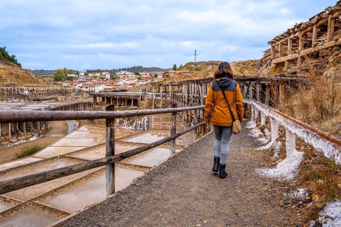 Woman exploring the ancient salt flats of anana, finding herself immersed in the historical