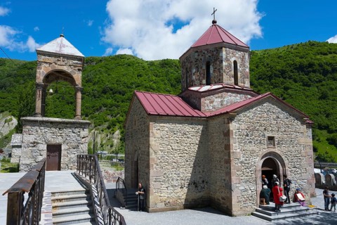Stone church with bell tower against green landscape and blue sky, Kvemo Mleta Lomis dome church,