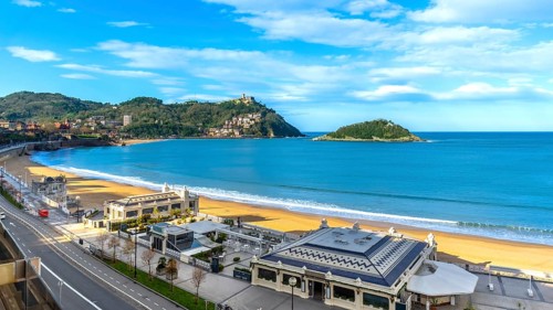 La concha bay beach with golden sand, santa clara island and mount igueldo rising above san