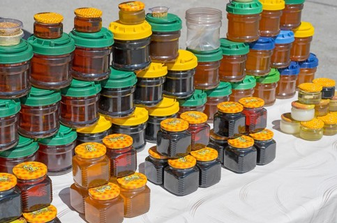Lots of colorful honey jars with various lids on a market stand, near Gudauri, Mtskheta-Mtianeti