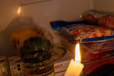 Blackout icon: Illuminating a dark refrigerator with a candle