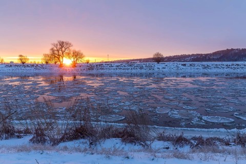 Cold winter morning on the Elbe with floating ice floes, snow and dawn at sunrise, Kötzschenbroda,