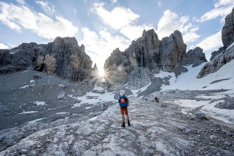 Mountaineers climbing a rocky mountain landscape with steep rock peaks to Bocca degli Armi, Sun