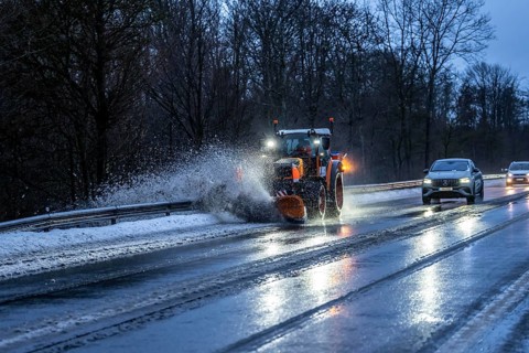 Winter service, spreader and snow plough in use, clears snow and slush from a regional road,