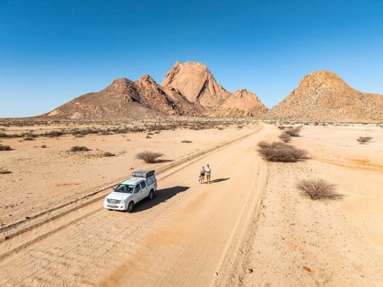 Car on sandy road, mountains in the desert, Spitzkoppe summit, Namib desert, Namibia