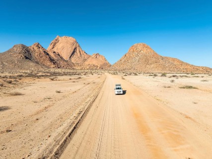 Aerial view, car on sandy road, mountains in the desert, Spitzkoppe summit, Namib desert, Namibia