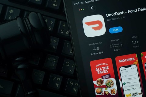 Dhaka, Bangladesh- 28 Oct 2025: An iPad displaying the DoorDash app against a judge's gavel and