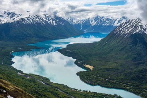 View of snowy mountains in spring and turquoise Kenai Lake with reflection, Slaughter Ridge Trail,