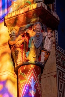 Issoire. Pillar (The Annunciation made to Mary) . The figures are illuminated by colorful light