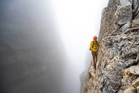 Mountaineers on a steep rock face on the Via Ferrata Oliva Detassis via ferrata in fog, steep