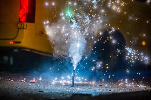 Burnt off fireworks are lying on the street, firecracker smoke produces smoke. New Year's night on