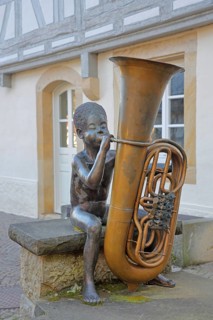 Sculpture boy with tuba by Guido Messer 1991, modern art, bronze sculpture, playing music, tuba,
