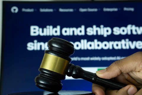 Dhaka, Bangladesh- 20 June 2025: A hand holds a gavel in front of a computer screen displaying