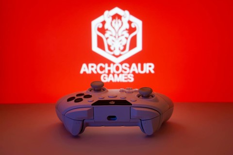 Dhaka, Bangladesh- 08 Apr 2025: A gaming controller in front of a Archosaur Games screen