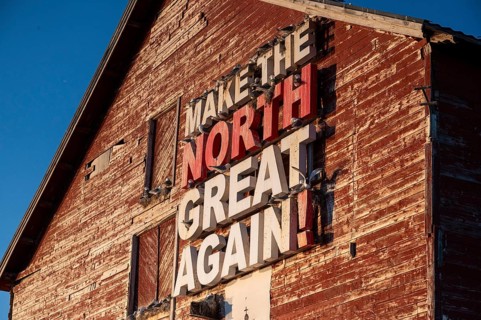 Red fishing building with the inscription Make the North great again at Vardö harbour, Vardø,