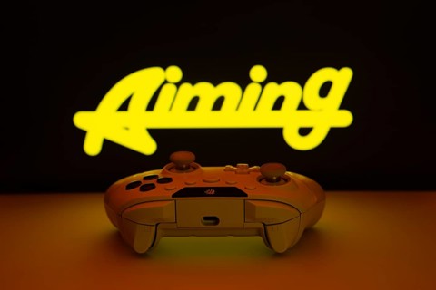 Dhaka, Bangladesh- 08 Apr 2025: A gaming controller in front of a Aiming Inc screen