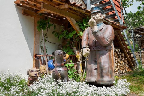 A man with dogs as a ceramic figure stands in front of the Keramik.um, an exhibition house