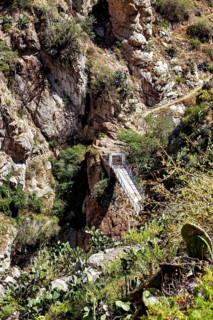 Suspension bridge that crosses a deep gorge between rocks, The landscape of the Colca Canyon in the