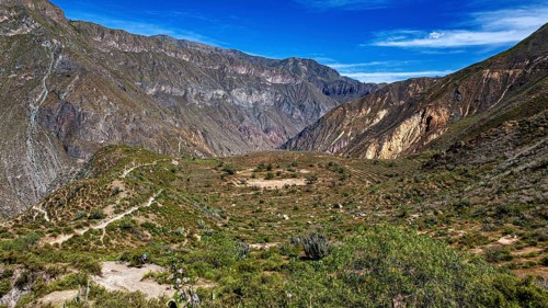Extensive valley with green hills under clear blue sky, the landscape of Colca Canyon in the Aden