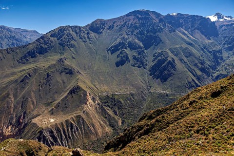 Extensive mountain landscape with a deep gorge, overgrown and under clear skies, The landscape of